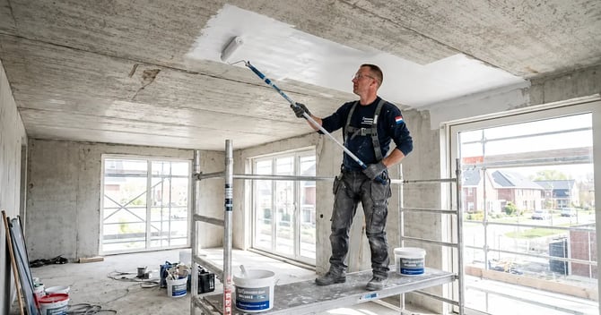 Plafond stucen in een renovatiewoning, waarbij een vakman het ruwe plafond strak afwerkt voor een glad en egaal resultaat.